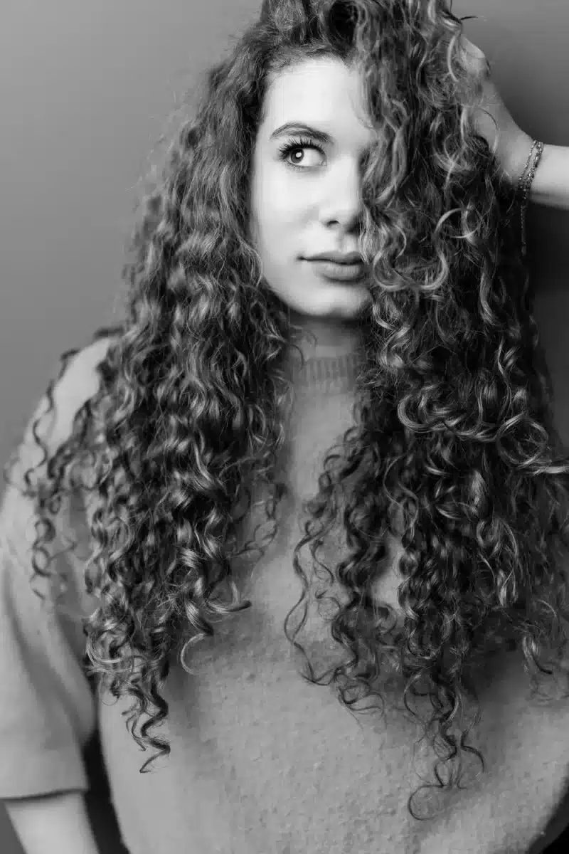 Portrait d'une adolescente se tenant les cheveux bouclés