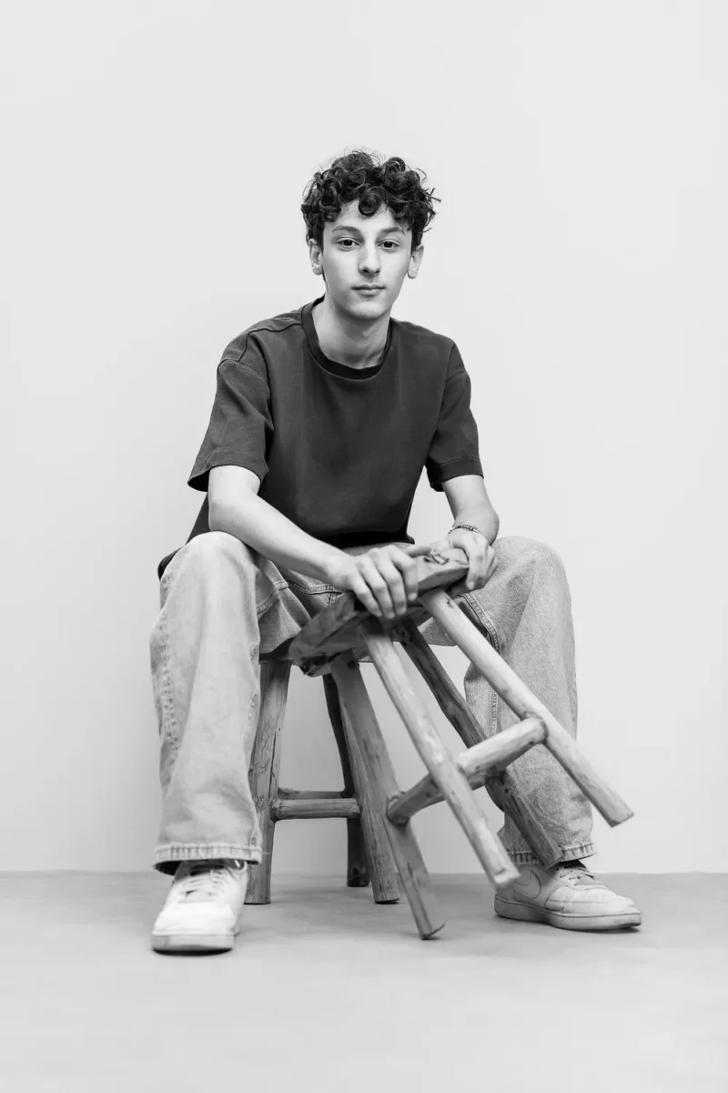 Cadeau original ado - Photo d'un jeune ado en noir et blanc avec un tabouret dans les mains en studio